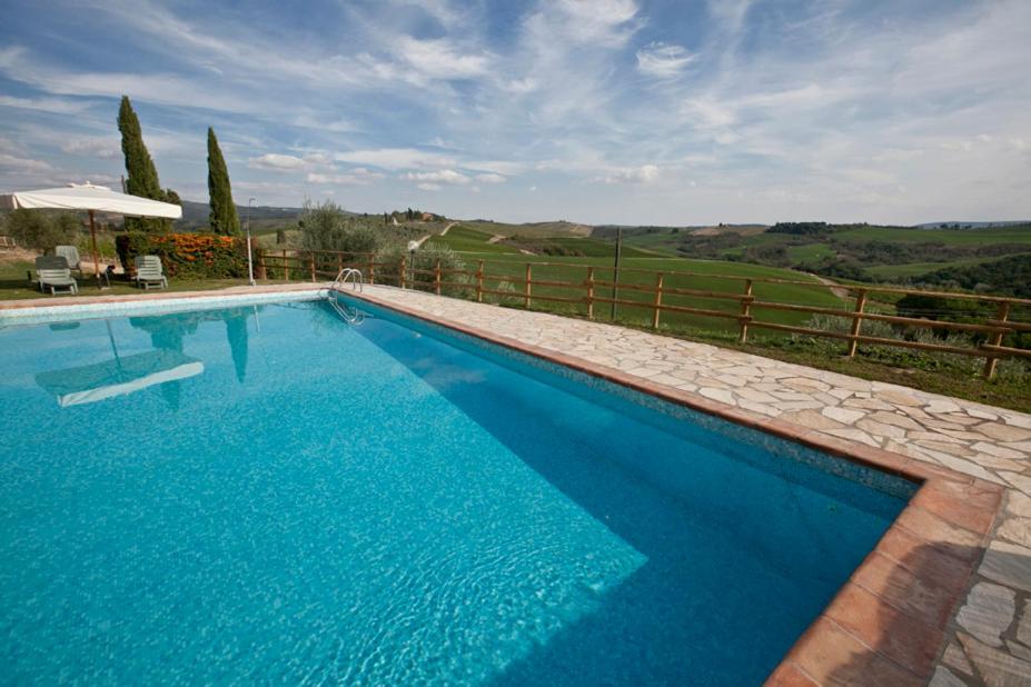 una gran piscina azul con una valla en Agriturismo il Torrione, en Poggibonsi