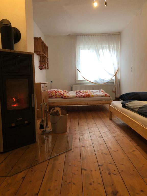 a bedroom with a fireplace and a bed and a window at Ferienwohnung am Leimsiederturm in Mühlhausen