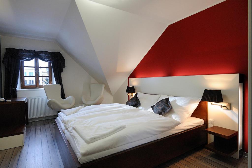 Schlafzimmer mit einem großen Bett mit einem roten Kopfteil in der Unterkunft Caramell in Louny