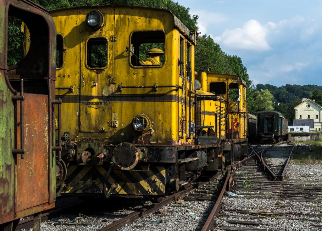 an old yellow train is sitting on the tracks at La Pause in Plombières