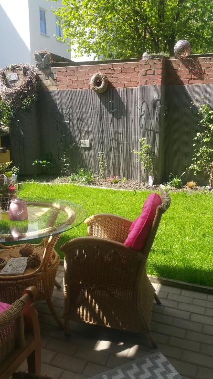 a patio with a table and a chair with a pink pillow at Ferienwohnung Halle Saale in Halle an der Saale