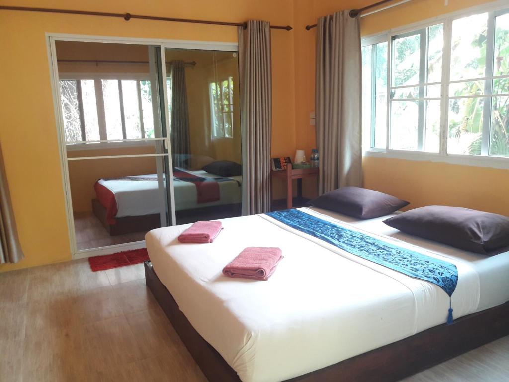 a bedroom with two beds and a mirror at JJ Beach Resort & JJ Seafood in Ko Phayam