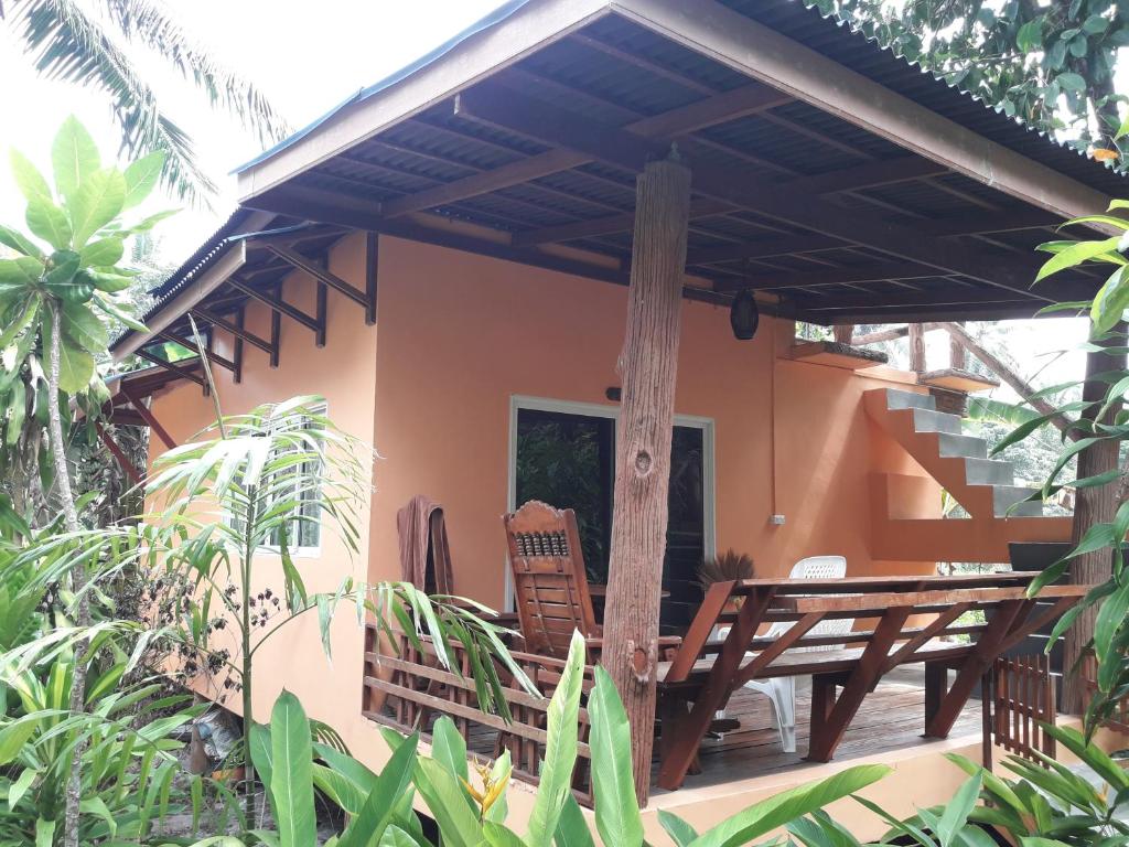 a porch of a house with a table and chairs at JJ Beach Resort & JJ Seafood in Ko Phayam