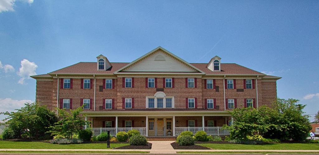 ein großes rotes Backsteingebäude mit einer Veranda in der Unterkunft Selinsgrove Inn in Selinsgrove