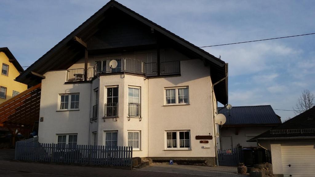 a large white house with a black roof at Ferienwohnung Rucksack-Bimbes in Altendiez