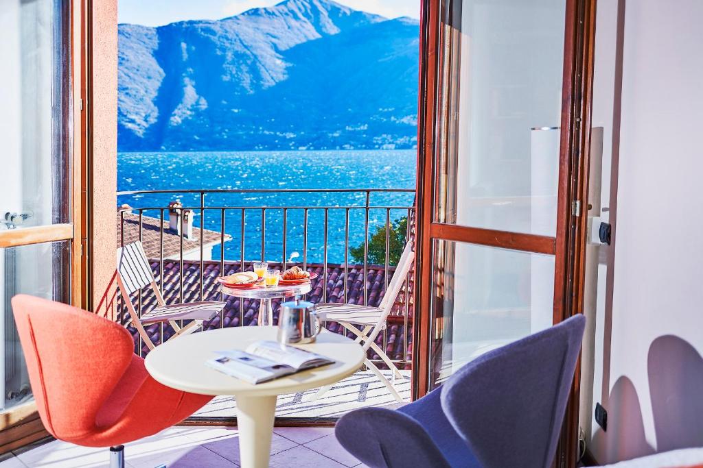 een kamer met een balkon met een tafel en stoelen bij Le Quattro Stagioni Lakeview in Acquaseria