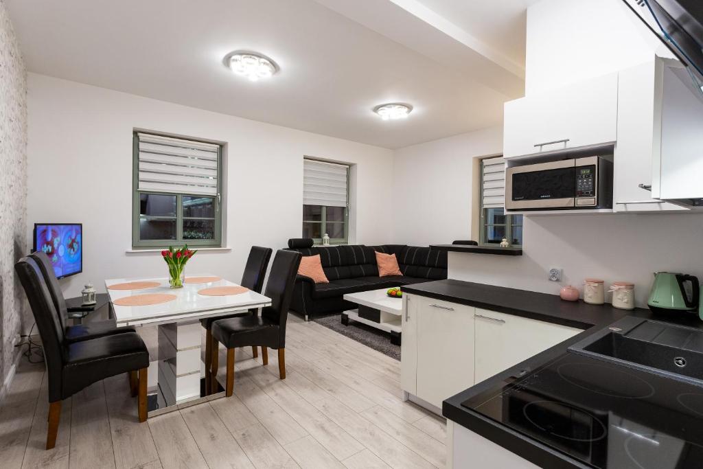 a kitchen and living room with a table and chairs at Apartament Rynek Sienny 1 in Szczecin