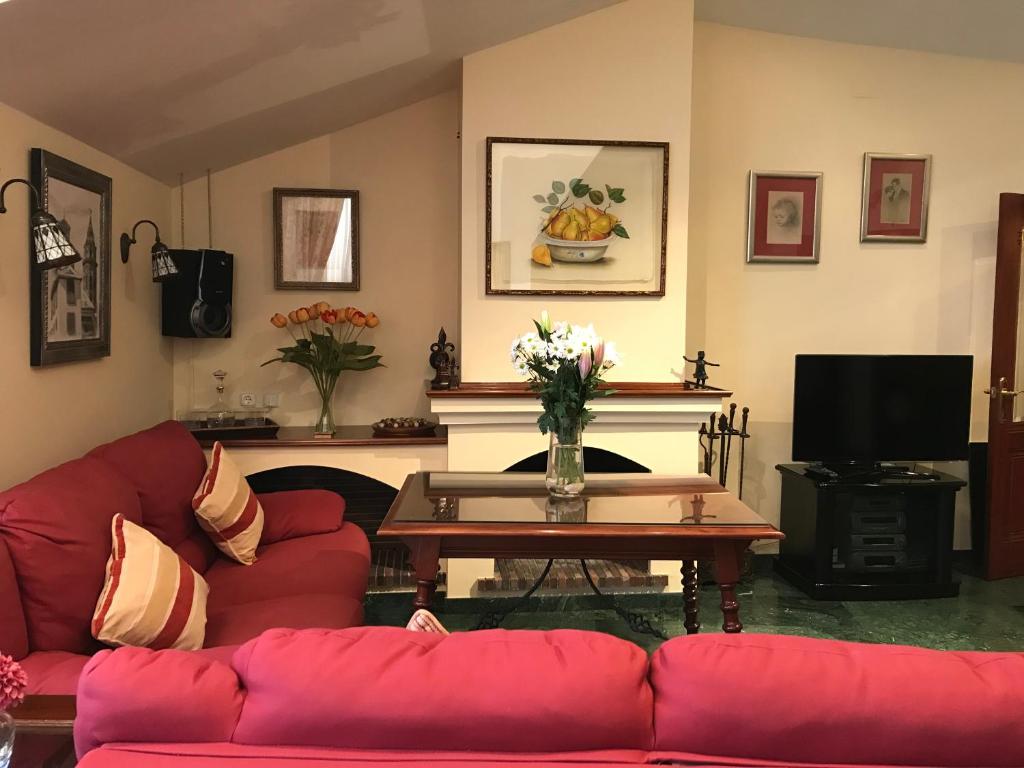 a living room with a red couch and a table at LA ATALAYA GREAT LUXURY ATTIC in Antequera