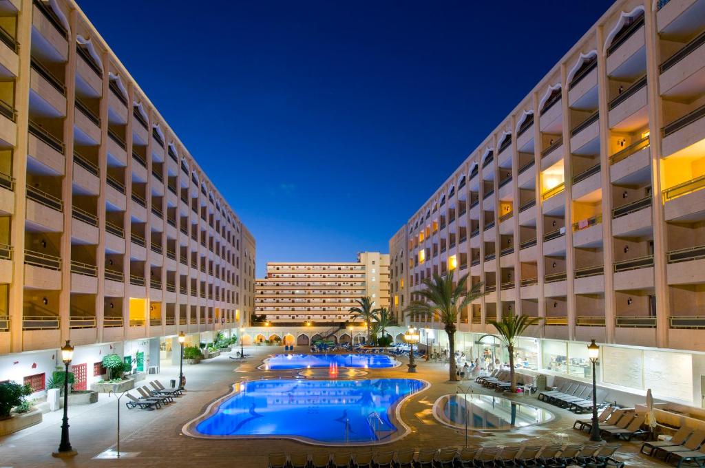 un patio del hotel con 2 piscinas y un edificio en Kn Aparthotel Columbus, en Playa de las Américas