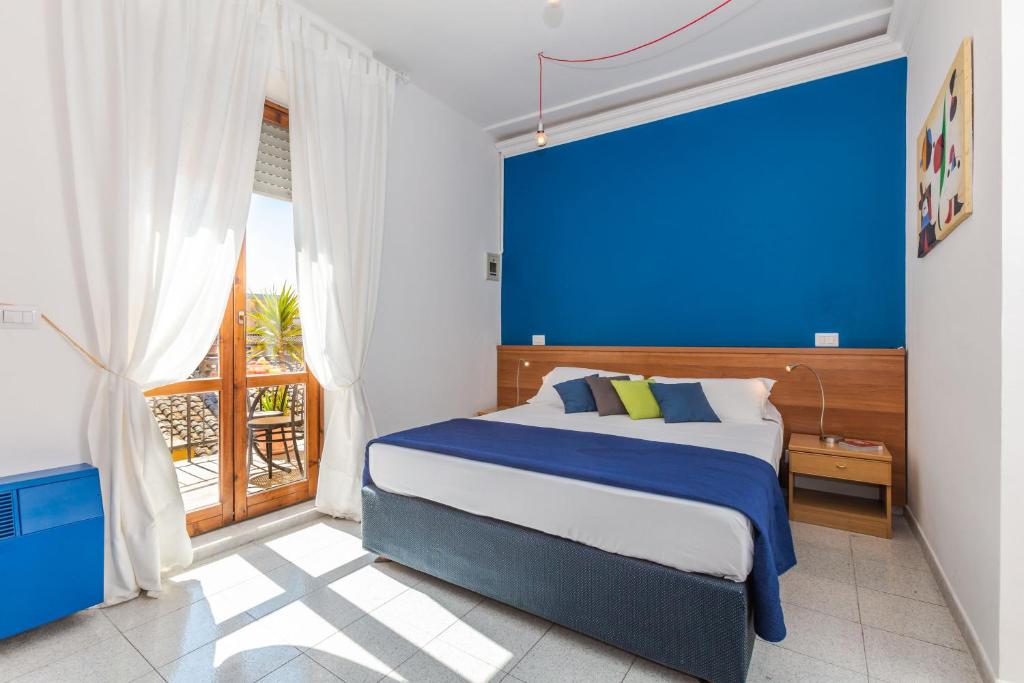 Schlafzimmer mit einem Bett mit blauer Wand in der Unterkunft Hotel Viterbo Inn in Viterbo