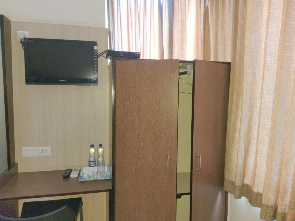 TV a/nebo společenská místnost v ubytování Banyan Tree Comforts Mysore