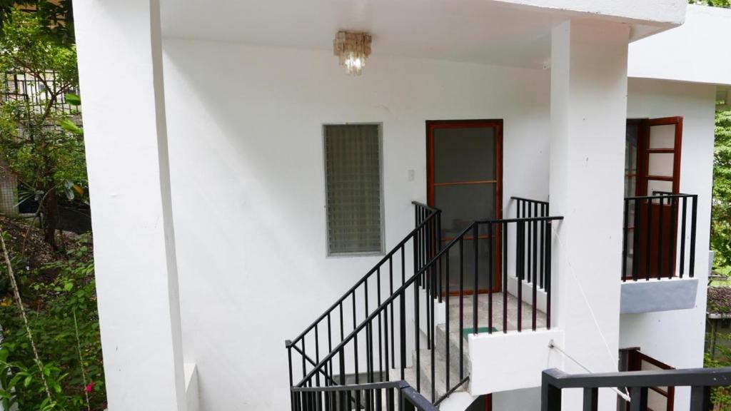 a white house with stairs and a window at JSB Residences Cebu A-flat in Tugbongan