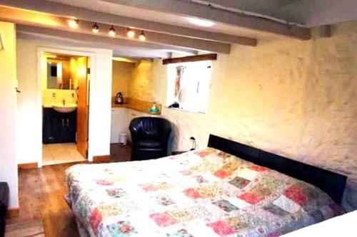 1 dormitorio con 1 cama con edredón en Wheelwrights, en Abbotsbury
