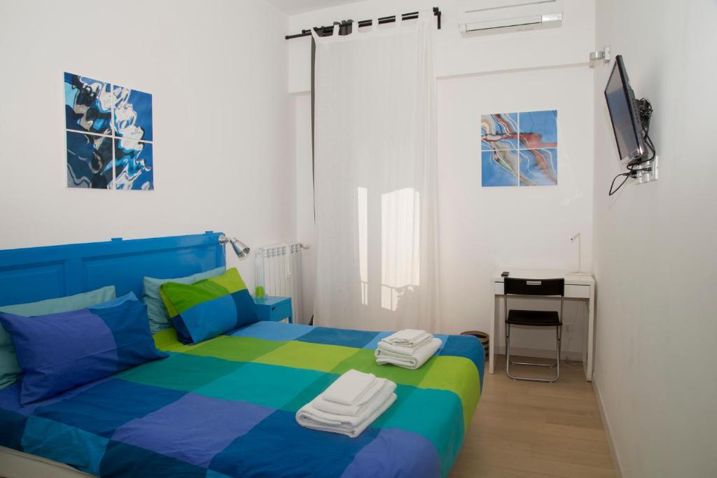 a bedroom with a blue and green bed and a television at LA PAUSA in Rome