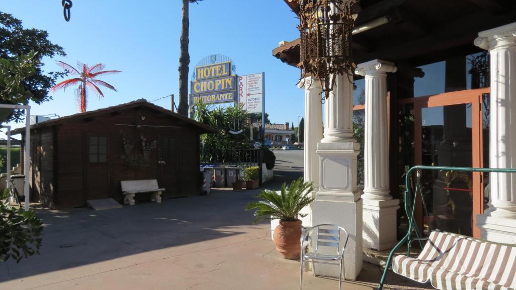 a porch of a store with a chair and a chandelier at Hotel Chopin in Fiumicino
