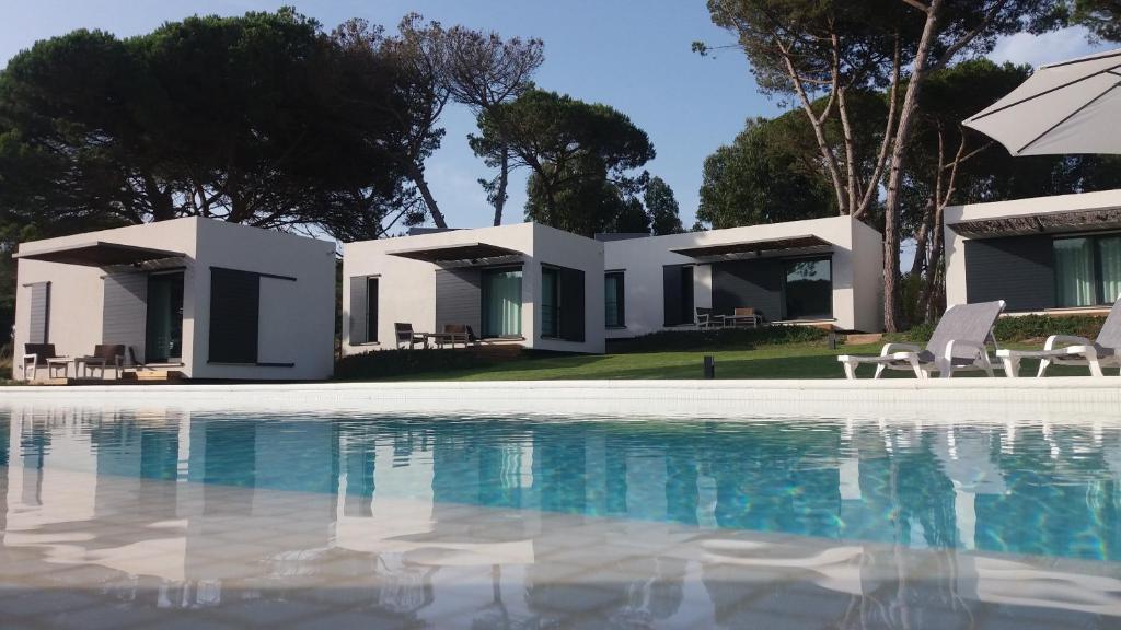 a villa with a swimming pool in front of a house at Casa Rio da Prata in Aldeia do Meco