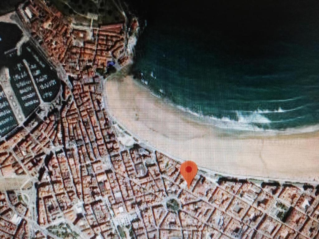 uma vista superior de uma praia com um ponto vermelho em Apartamento Centro y Playa em Gijón