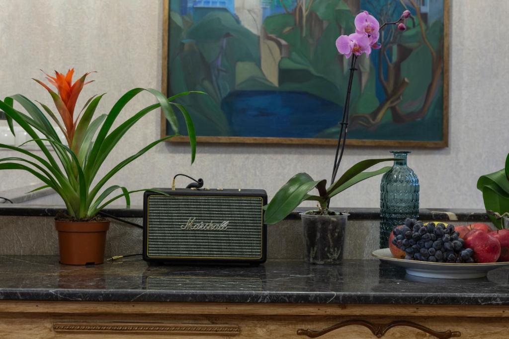 a table with a radio and a bowl of fruit at Omart Hotel - Gallery in Tbilisi City