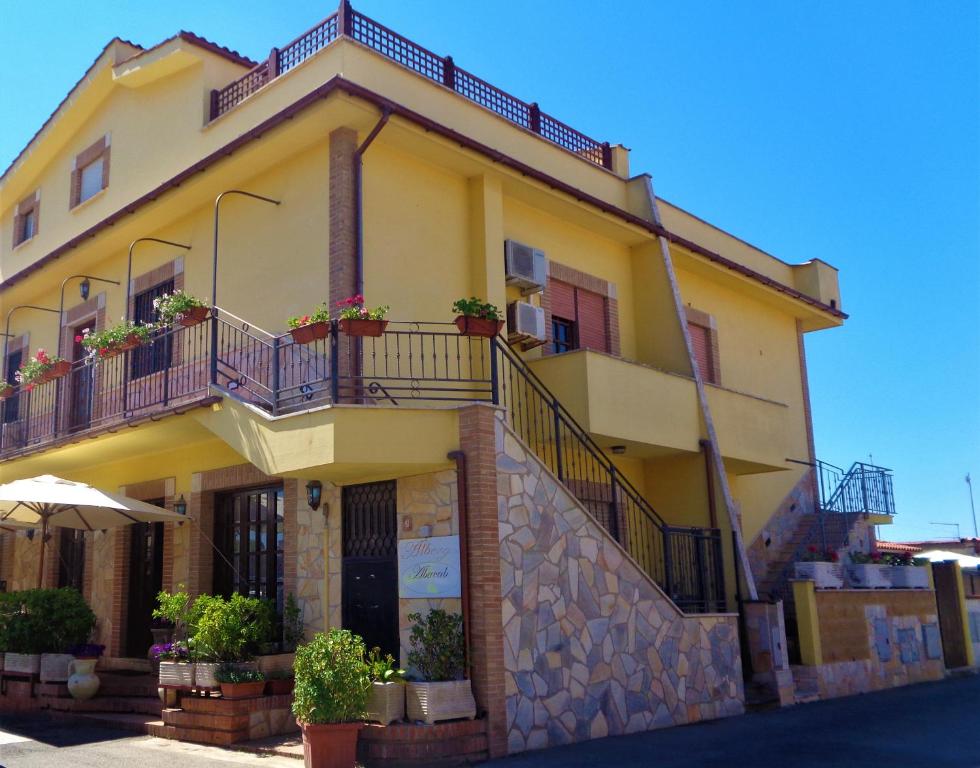 un edificio amarillo con macetas en los balcones en Abacab, en Passoscuro