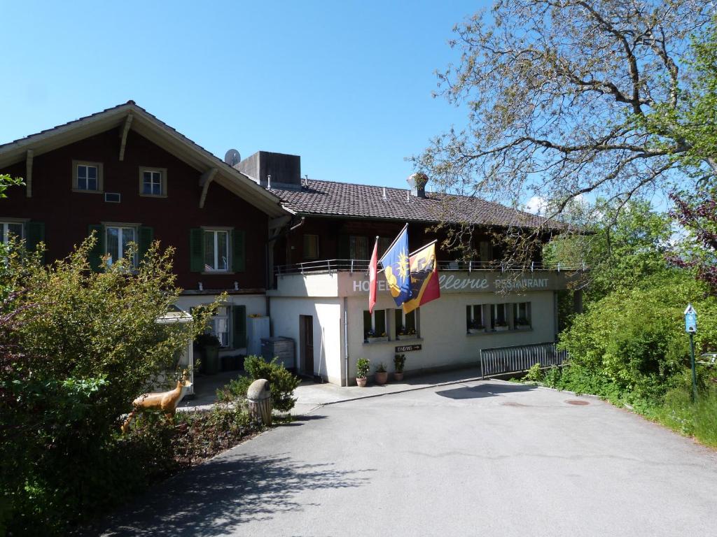 una casa con banderas a un lado de la carretera en Hotel Bellevue en Heiligenschwendi