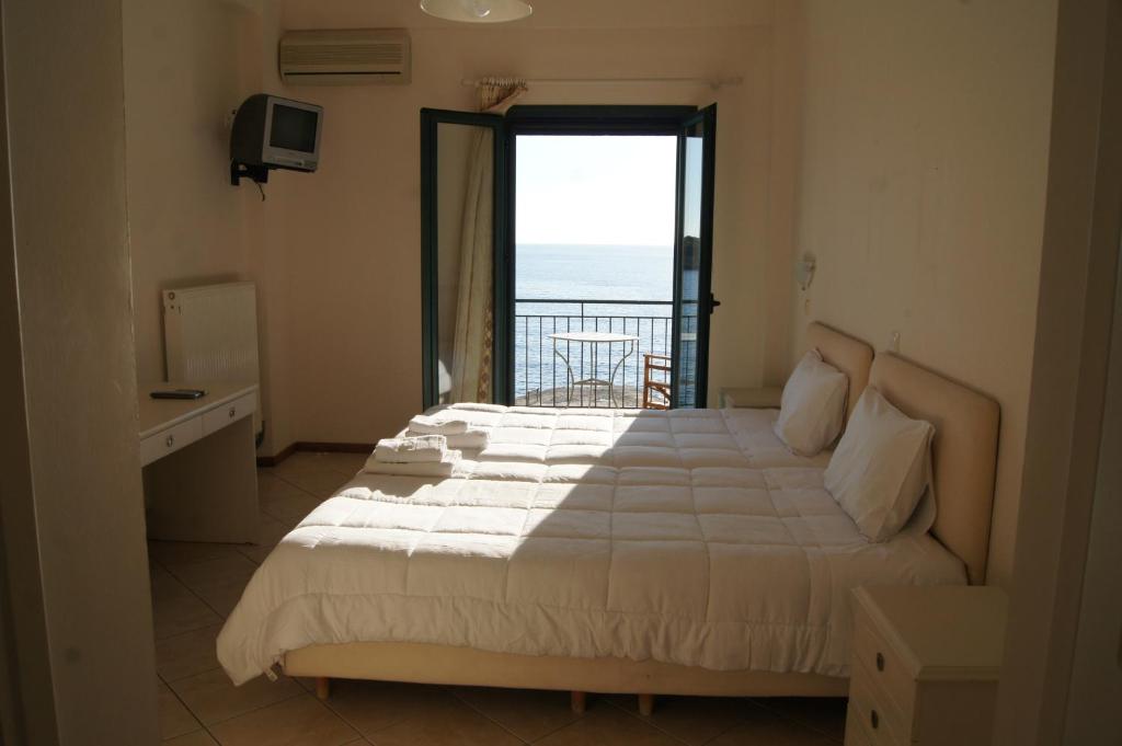 a bedroom with a bed with a view of the ocean at Gorgones, sea-front, great view in Kardamyli