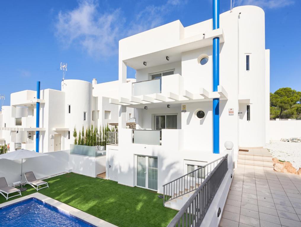 a white building with a swimming pool in front of it at Casa Bianca in Cala Vadella