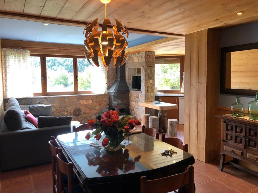 a living room with a table with flowers on it at Apartaments Piteus Casa Dionis in Sant Llorenç de Morunys