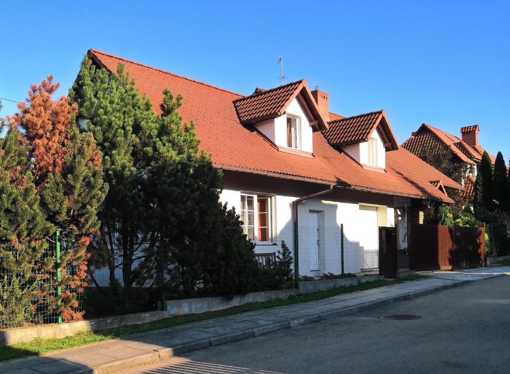 een wit huis met een oranje dak op een straat bij Willa Elżbieta in Krakau