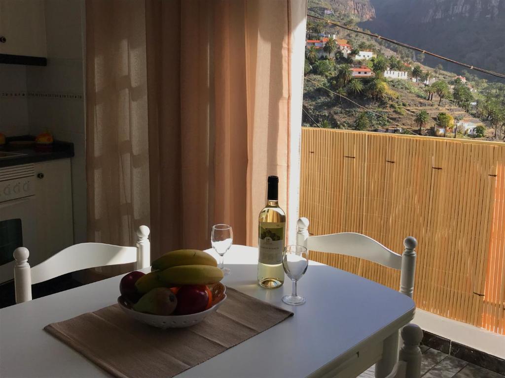 un tavolo con un cesto di frutta e una bottiglia di vino di Alojamiento San Antonio a Valle Gran Rey