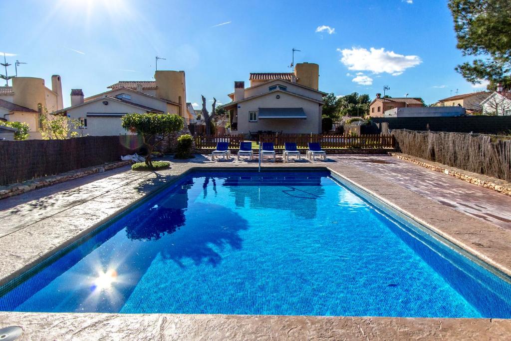 una piscina con sillas y una casa en Casa Montse Barà, en Roda de Bará