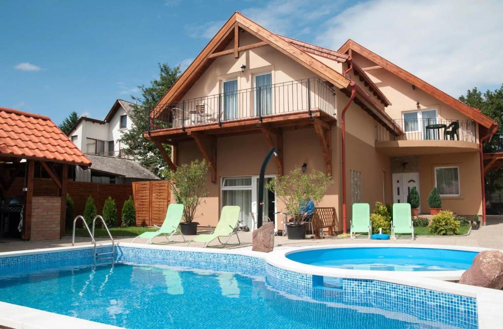 a house with a swimming pool in front of a house at Borostyán Panzió Balatonfüred in Balatonfüred