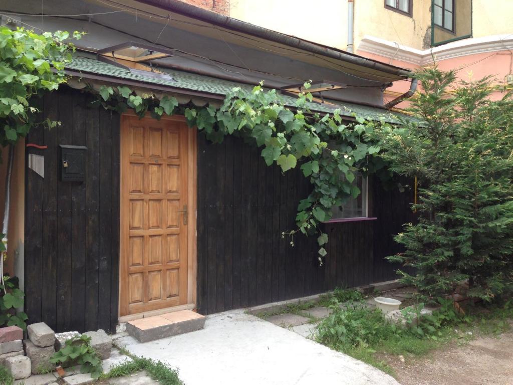 クルジュ・ナポカにあるGreen House Apartmentの木の扉とブドウの木がある家