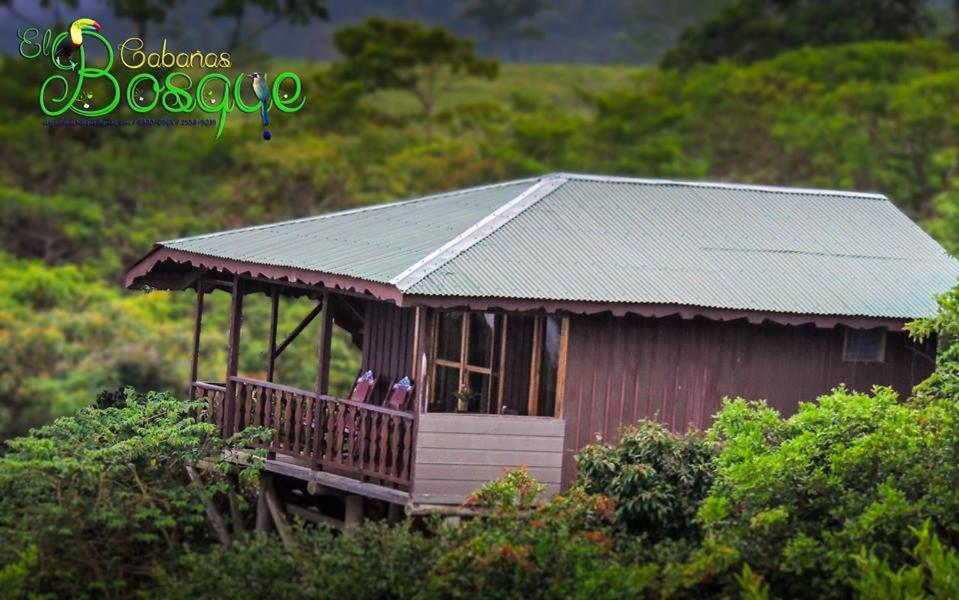 a small house with two people standing on a porch at Cabañas el Bosque in Turrialba