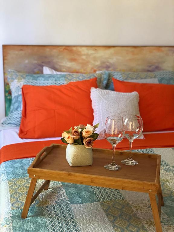 a table with two wine glasses and flowers on a bed at Villa Florencia Bavaro in Punta Cana