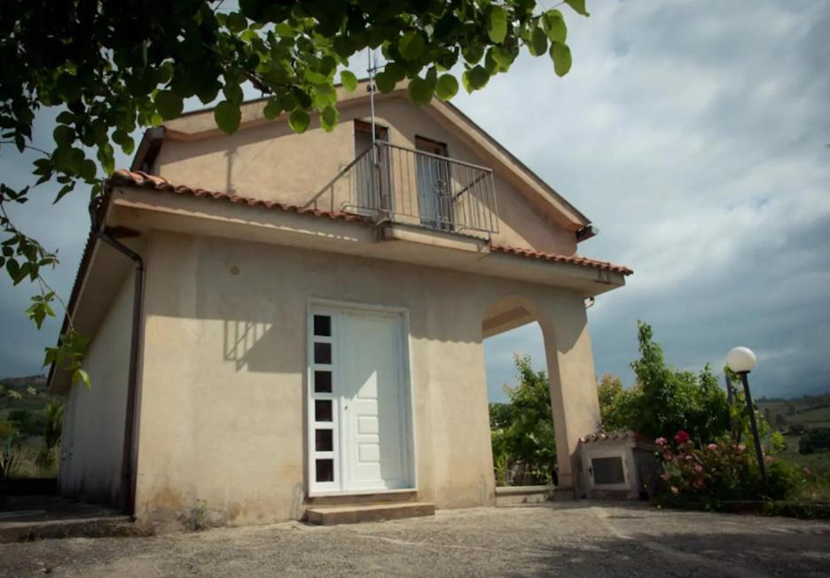 a small house with a balcony on top of it at Villetta nel Verde in Ascea