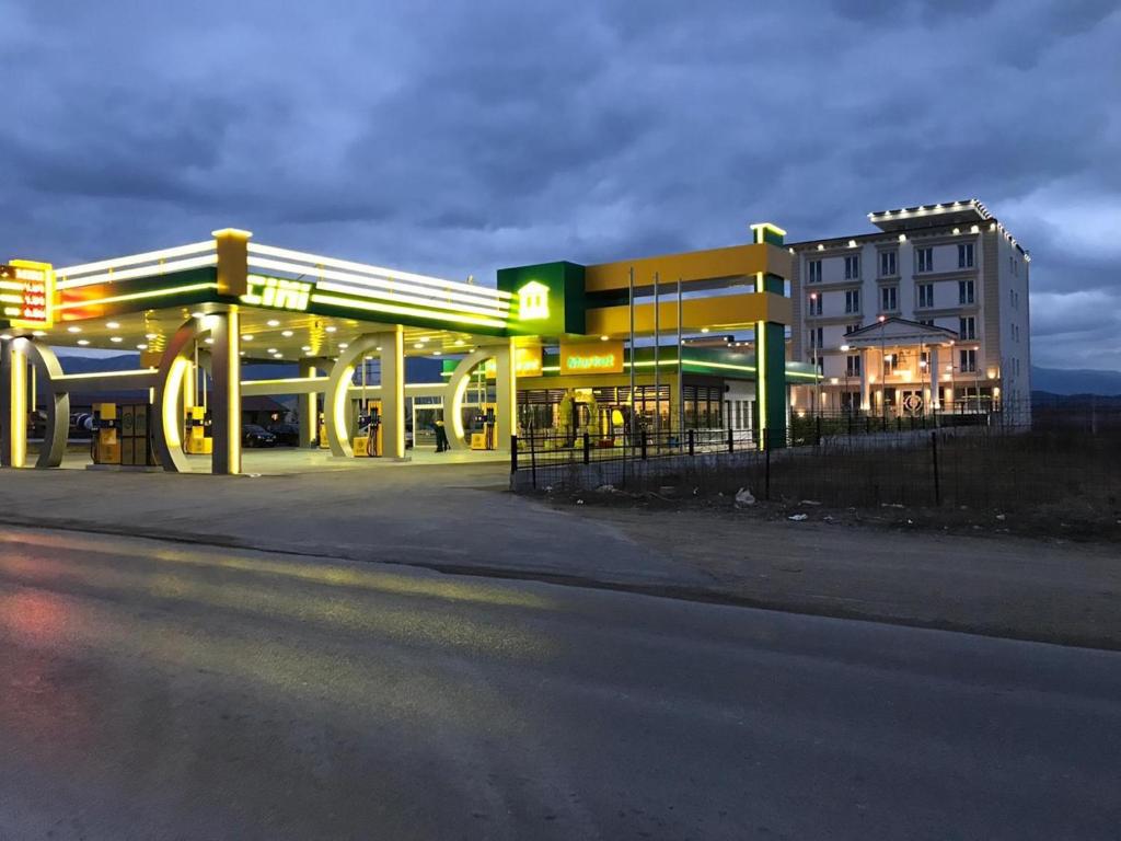 una gasolinera frente a un edificio por la noche en Theranda Hotel en Prizren