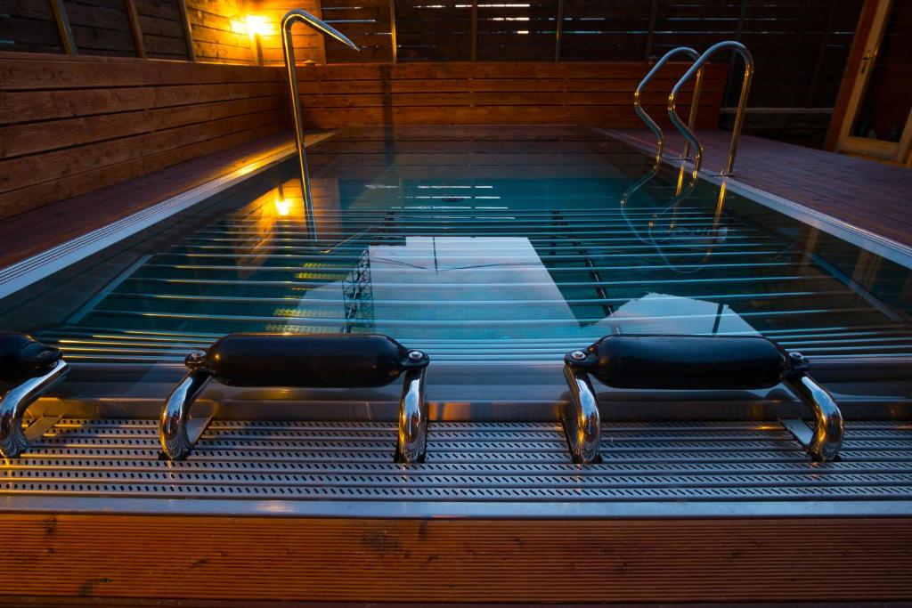Una piscina de agua con dos sillas. en VIP Apartamenty Gorska Odskocznia SPA, en Zakopane