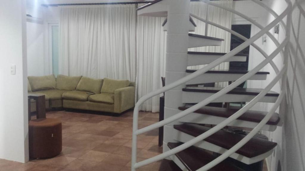 escalera de caracol en una sala de estar con sofá en FLAT 212 Condomínio Villa Hípica Gravatá, en Gravatá