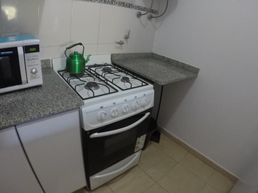 La cocina está equipada con fogones y hervidor de agua con té verde. en departamento catalina en Colón