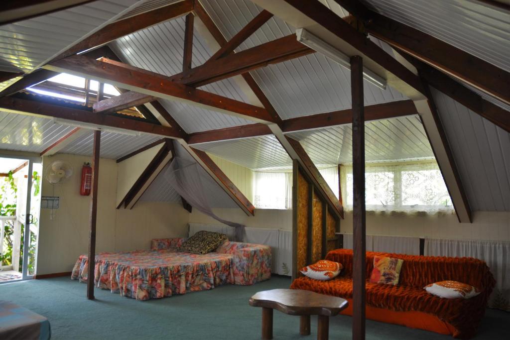 a attic room with a bed and a couch at Fare Maheata in Pihaena