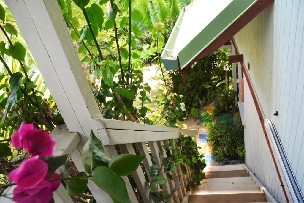 a stairway with a bench and pink flowers at Fare Maheata in Pihaena
