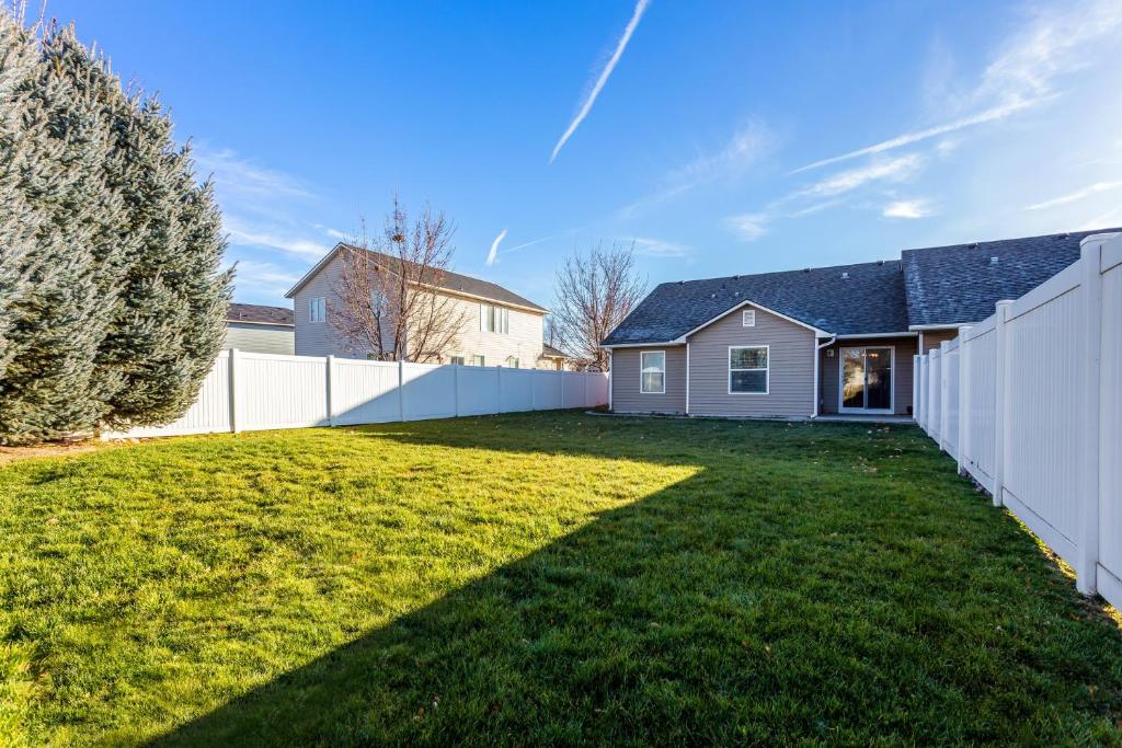 a backyard with a white fence and a house at Gray Cloud Townhomes in Meridian