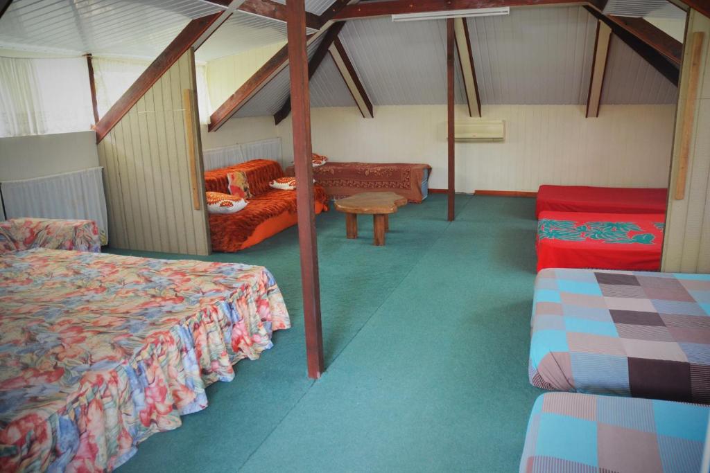 a room with two beds and a bench in it at Fare Maheata in Pihaena