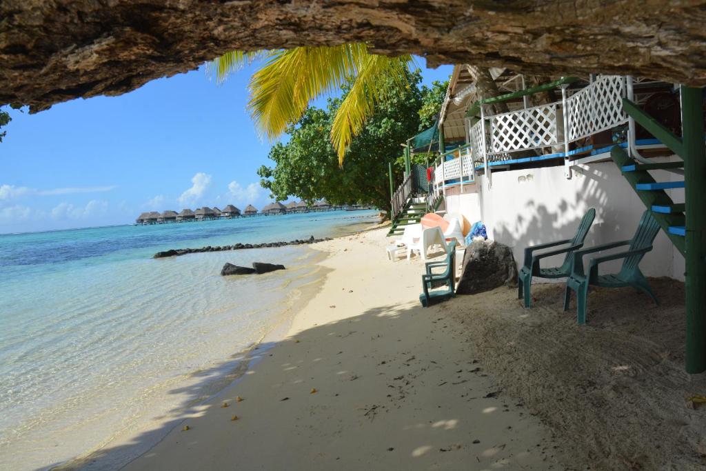 a beach with chairs and a building and the ocean at Fare Maheata in Pihaena