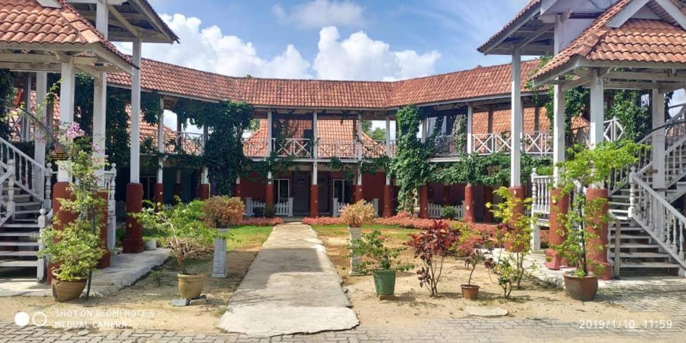 a building with a courtyard with potted plants at Iz Village in Kampung Kuala Besut