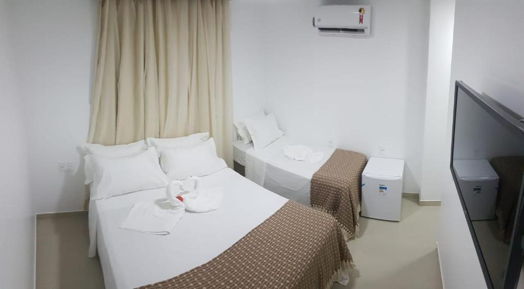 Habitación de hotel con 2 camas y TV de pantalla plana. en Cabanos Suites, en Maragogi