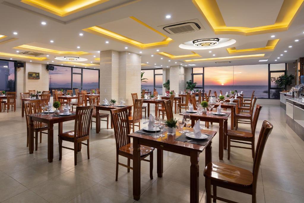 a dining room with tables, chairs, and tables at Corvin Hotel in Vung Tau