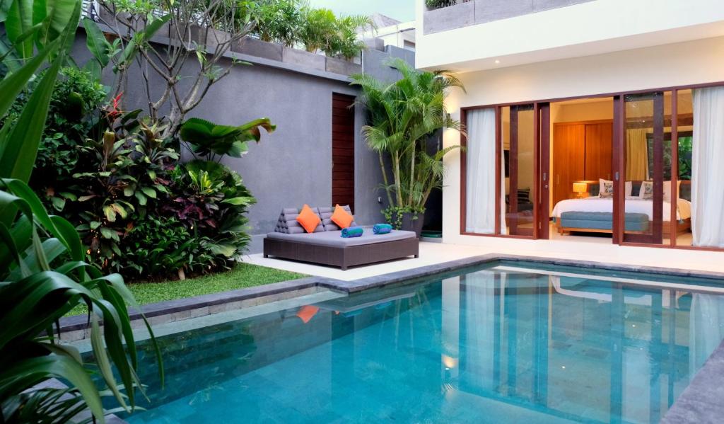 a villa with a swimming pool and a bedroom at Villa Sally in Canggu