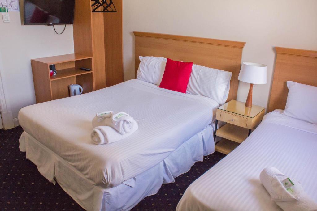 um quarto de hotel com duas camas com toalhas em Gardners Inn Hotel em Blackheath