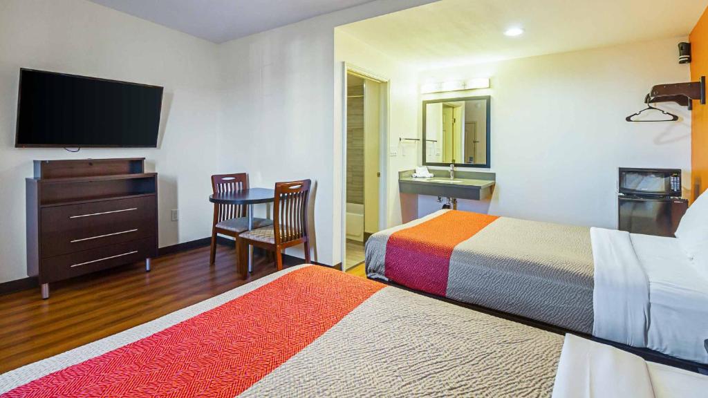 um quarto de hotel com duas camas e uma televisão de ecrã plano em Motel 6 Maple/Main em Hesperia